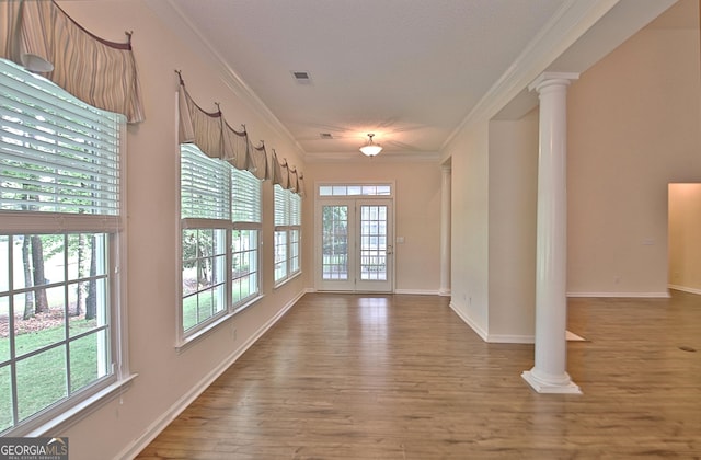 44 Arbor Way, Newnan, GA 30265 - unfurnished room with crown molding, ornate columns, plenty of natural light, wood finished floors, and baseboards