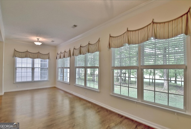 44 Arbor Way, Newnan, GA 30265 - unfurnished dining area with wood finished floors, baseboards, ornamental molding, and a textured ceiling