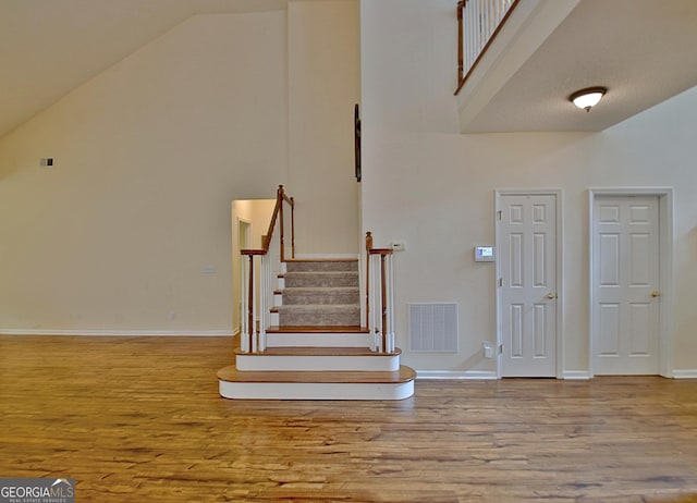 44 Arbor Way, Newnan, GA 30265 - stairway featuring wood finished floors, high vaulted ceiling, and baseboards