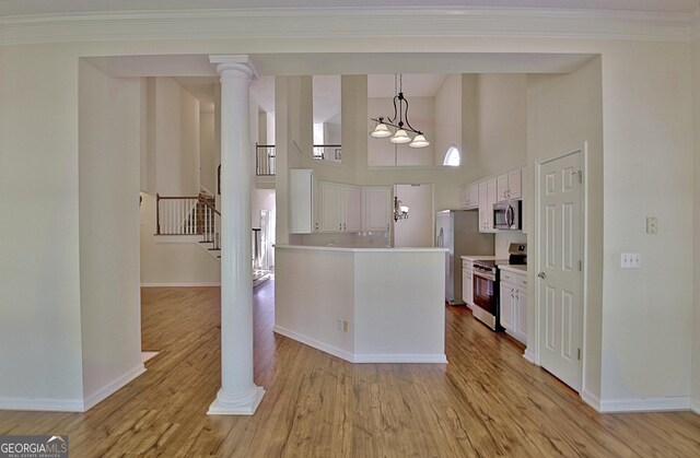 44 Arbor Way, Newnan, GA 30265 - kitchen featuring appliances with stainless steel finishes, high vaulted ceiling, light wood-style flooring, white cabinetry, and light countertops