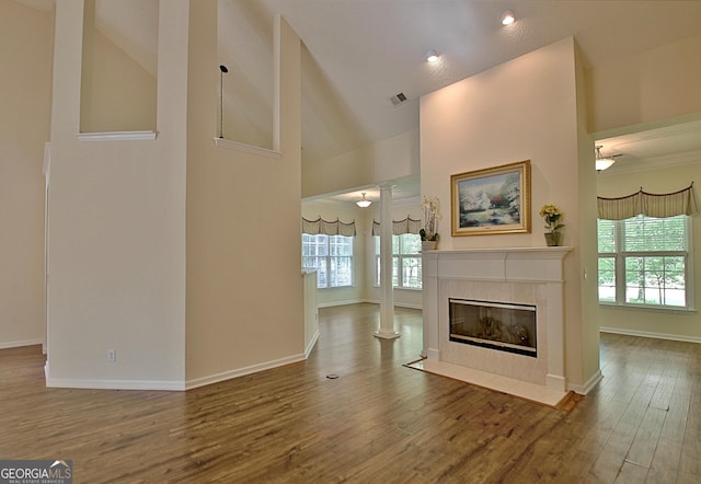 44 Arbor Way, Newnan, GA 30265 - unfurnished living room with high vaulted ceiling, a tile fireplace, healthy amount of natural light, baseboards, and wood finished floors
