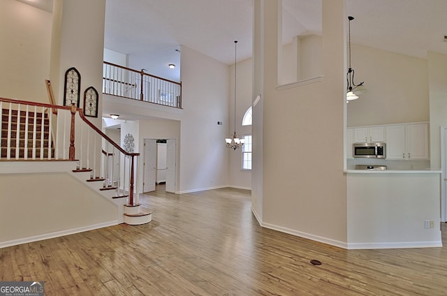 44 Arbor Way, Newnan, GA 30265 - foyer with high vaulted ceiling, light wood-style floors, stairway, baseboards, and a chandelier