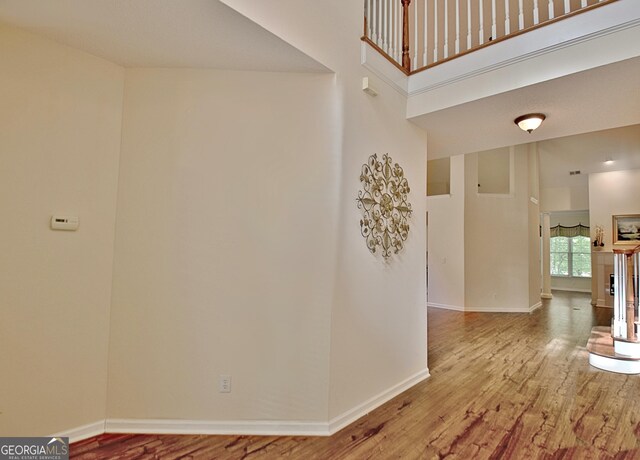 44 Arbor Way, Newnan, GA 30265 - corridor featuring wood finished floors, a high ceiling, and baseboards