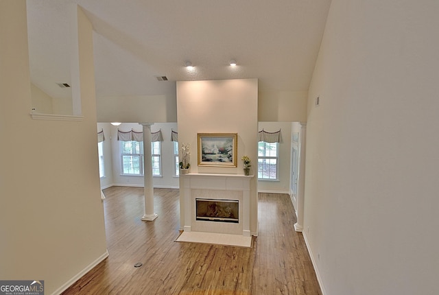44 Arbor Way, Newnan, GA 30265 - unfurnished living room featuring healthy amount of natural light, wood finished floors, baseboards, and a tiled fireplace