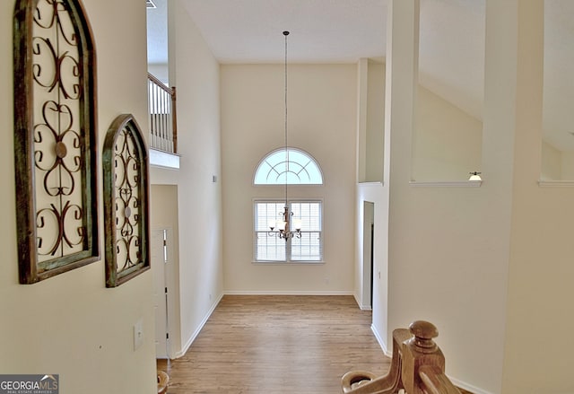 44 Arbor Way, Newnan, GA 30265 - foyer entrance featuring a high ceiling, a chandelier, wood finished floors, and baseboards