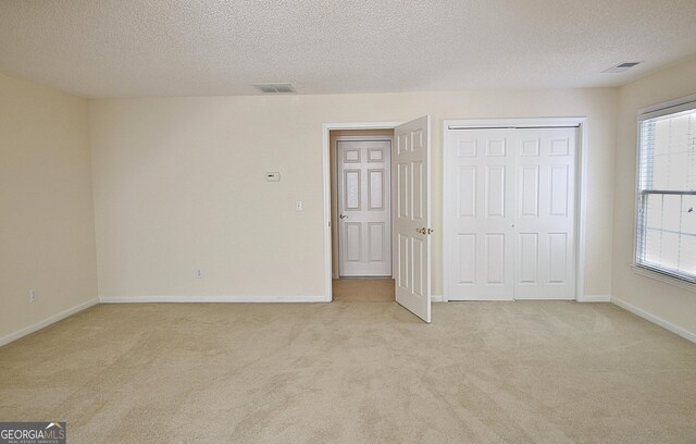 44 Arbor Way, Newnan, GA 30265 - unfurnished bedroom with light colored carpet, a textured ceiling, baseboards, and a closet