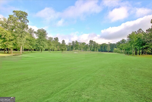 44 Arbor Way, Newnan, GA 30265 - surrounding community with view of wooded area, view of golf course, and a lawn