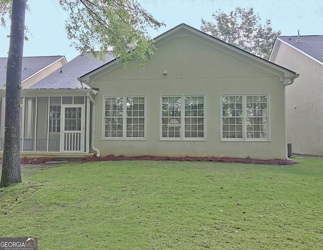 44 Arbor Way, Newnan, GA 30265 - rear view of house featuring a lawn, a sunroom, stucco siding, and roof with shingles