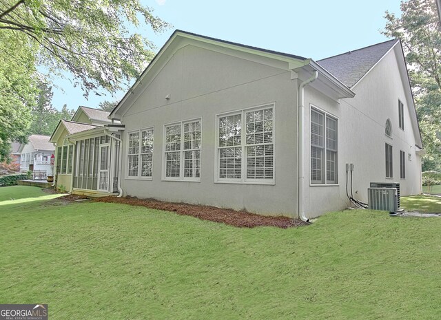 44 Arbor Way, Newnan, GA 30265 - view of side of home featuring cooling unit, a yard, a sunroom, and stucco siding