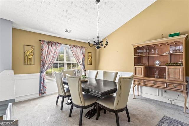 995 Chimney Trace Way, Lawrenceville, GA 30045 - dining space with a chandelier, light colored carpet, a textured ceiling, lofted ceiling, and wainscoting