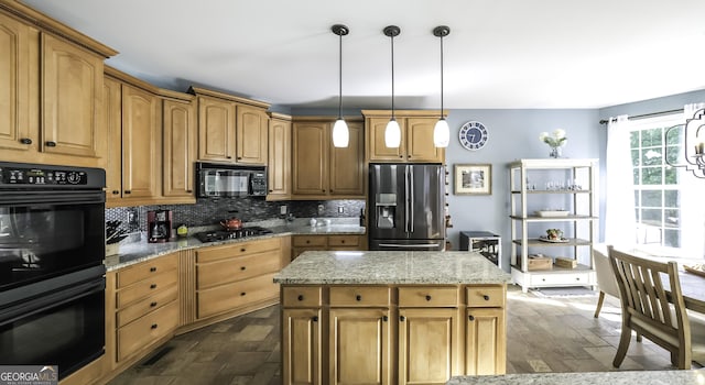 kitchen featuring black appliances, backsplash, light stone counters, hanging light fixtures, and a center island