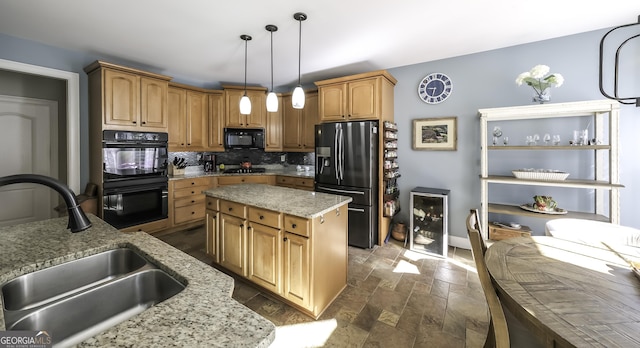 kitchen featuring black appliances, a sink, backsplash, light stone counters, and dark stone finish flooring