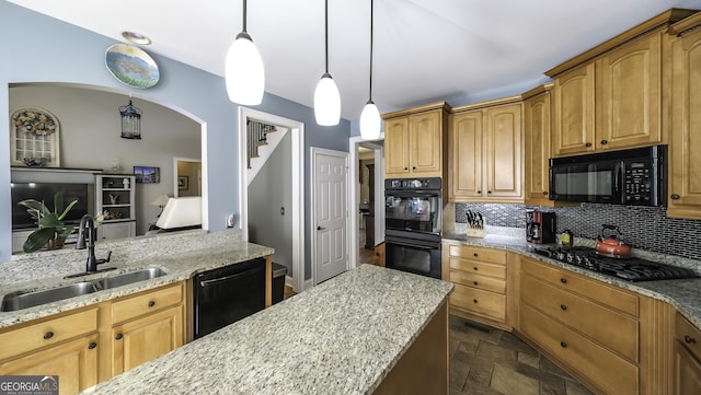 kitchen featuring black appliances, a sink, decorative backsplash, and light stone counters
