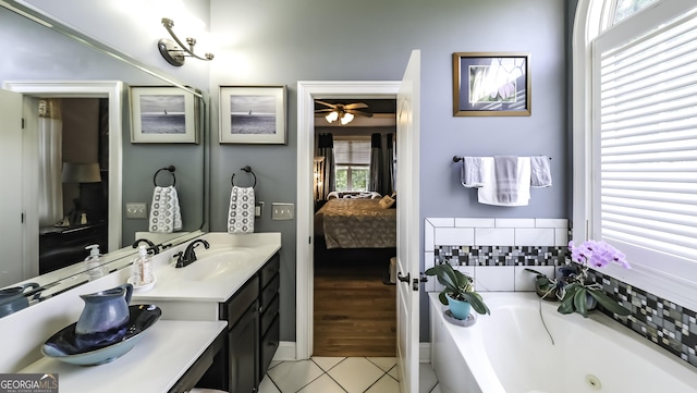 full bath featuring ensuite bath, tile patterned flooring, a tub with jets, vanity, and ceiling fan