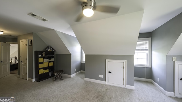 bonus room with a ceiling fan, light carpet, baseboards, and vaulted ceiling