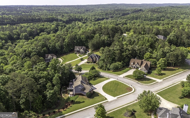 aerial view of property and surrounding area featuring a heavily wooded area
