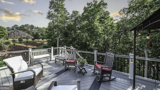 wooden terrace featuring view of wooded area