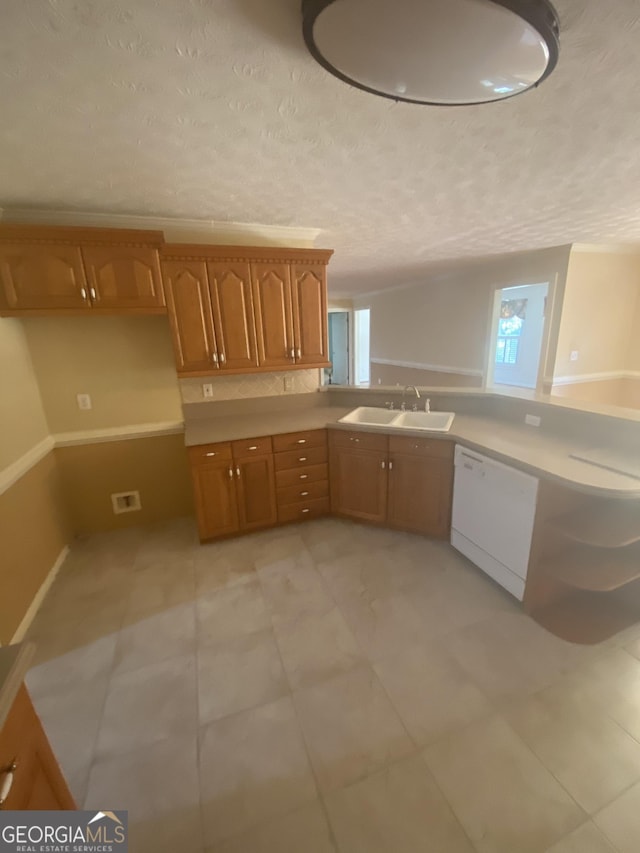 1669 Azalea Dr, Lawrenceville, GA 30043 - kitchen featuring white dishwasher, a sink, brown cabinetry, a textured ceiling, and light countertops