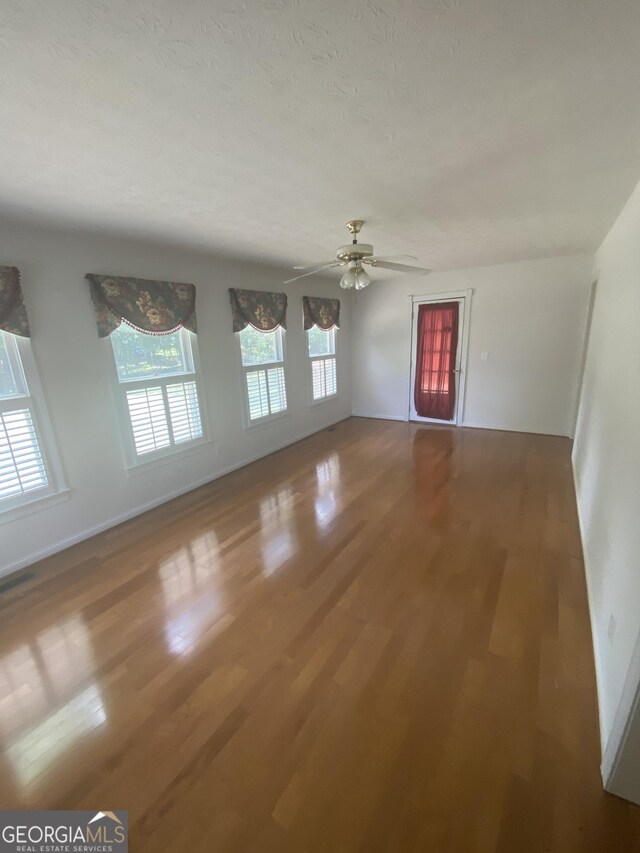 1669 Azalea Dr, Lawrenceville, GA 30043 - unfurnished living room featuring wood finished floors, ceiling fan, and baseboards