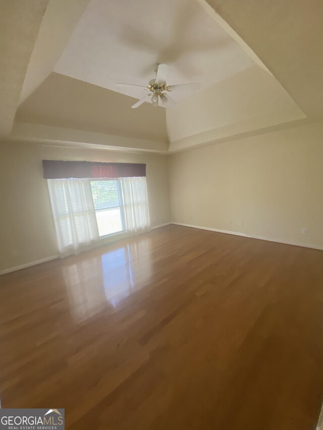 1669 Azalea Dr, Lawrenceville, GA 30043 - spare room with a raised ceiling, a ceiling fan, baseboards, and wood finished floors