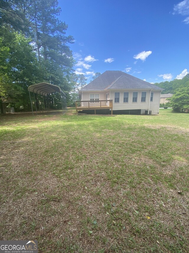 1669 Azalea Dr, Lawrenceville, GA 30043 - back of house featuring a carport, a deck, and a lawn