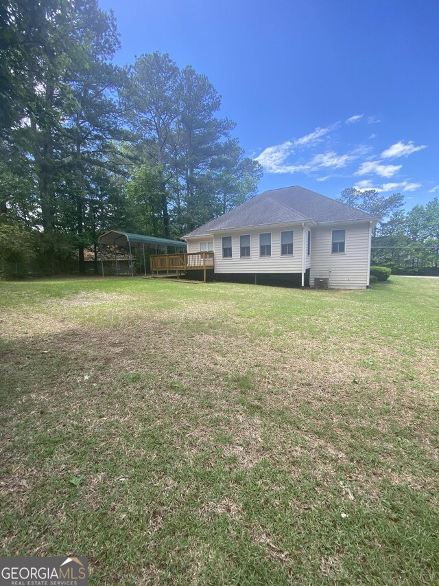 1669 Azalea Dr, Lawrenceville, GA 30043 - back of property featuring a carport, a yard, a wooden deck, and roof with shingles