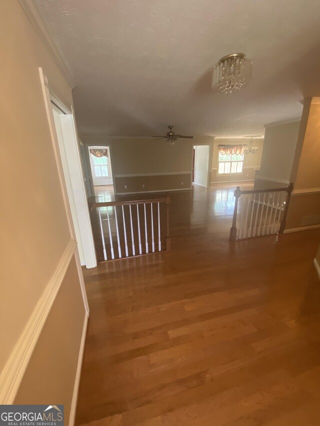 1669 Azalea Dr, Lawrenceville, GA 30043 - hallway featuring wood finished floors, healthy amount of natural light, ornamental molding, and a chandelier