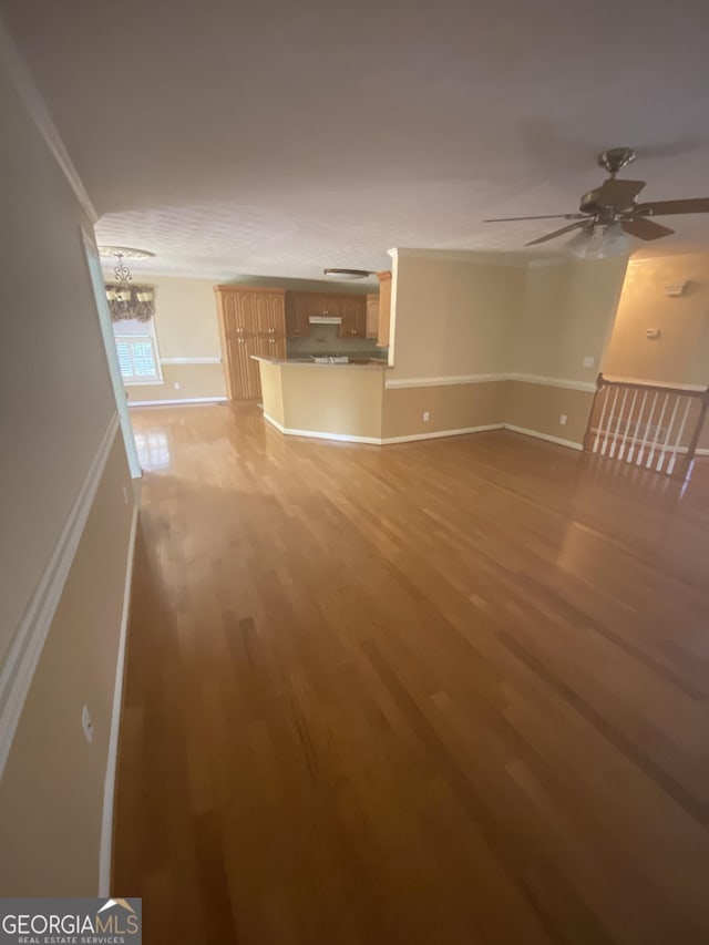 1669 Azalea Dr, Lawrenceville, GA 30043 - unfurnished living room featuring light wood-type flooring, ornamental molding, a chandelier, baseboards, and ceiling fan