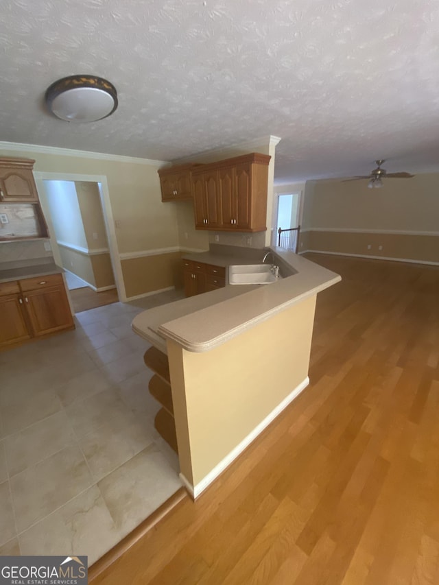1669 Azalea Dr, Lawrenceville, GA 30043 - kitchen with a sink, baseboards, a peninsula, a textured ceiling, and ceiling fan