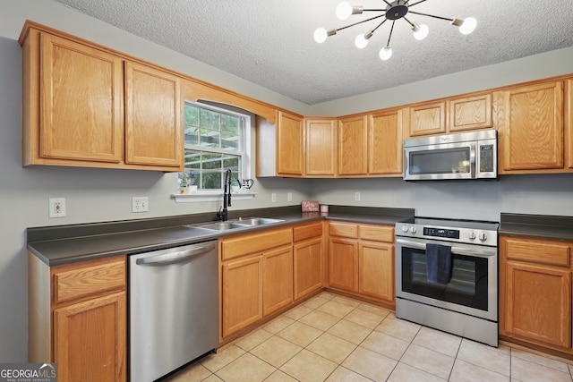194 Retreat Pl, Woodbine, GA 31569 - kitchen with stainless steel appliances, dark countertops, light tile patterned floors, a chandelier, and a textured ceiling