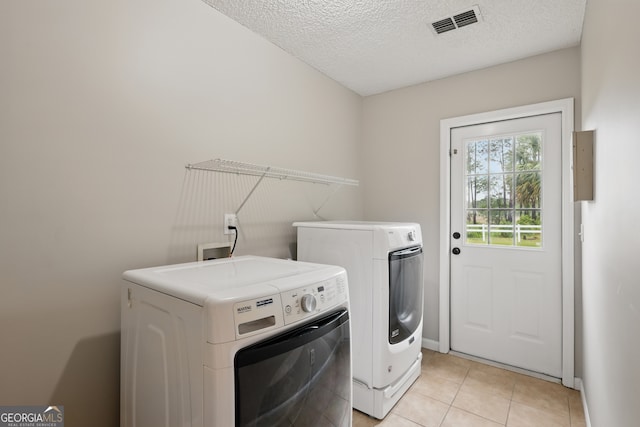 194 Retreat Pl, Woodbine, GA 31569 - laundry room featuring washer and dryer, a textured ceiling, and light tile patterned floors