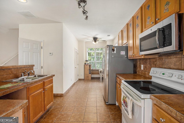 2770 Nautical Way, Villa Rica, GA 30180 - kitchen featuring stainless steel appliances, brown cabinets, and tasteful backsplash