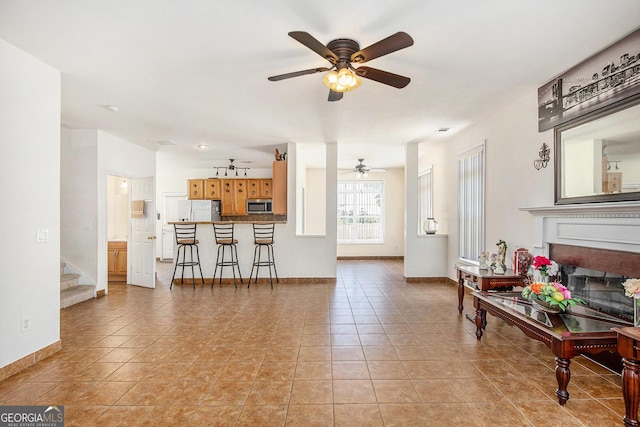 2770 Nautical Way, Villa Rica, GA 30180 - living area with ceiling fan, a fireplace, stairs, and light tile patterned flooring