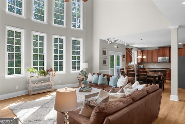 7049 Bennington Ln, Cumming, GA 30041 - living room featuring a towering ceiling, light wood-type flooring, ceiling fan, ornate columns, and recessed lighting