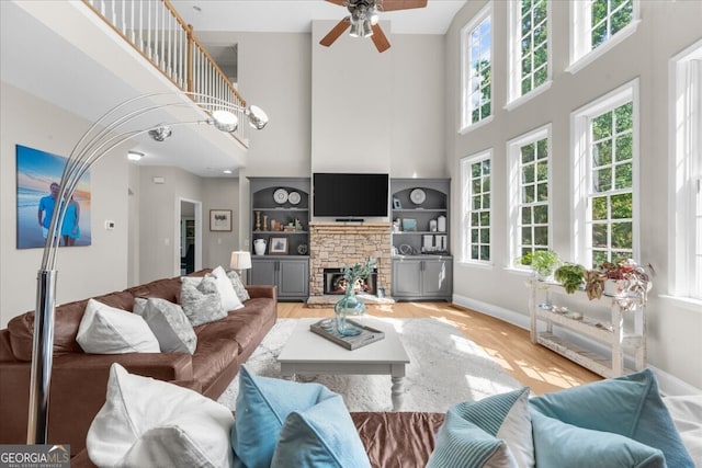 7049 Bennington Ln, Cumming, GA 30041 - living room featuring a towering ceiling, healthy amount of natural light, light wood-style flooring, and a ceiling fan