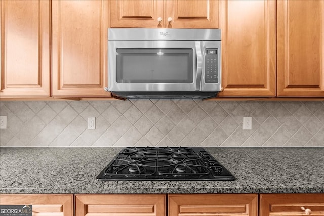 7049 Bennington Ln, Cumming, GA 30041 - kitchen featuring stainless steel microwave, black gas stovetop, backsplash, and dark stone countertops