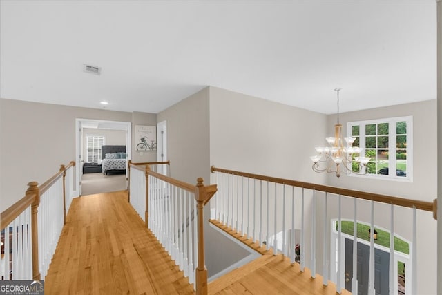 7049 Bennington Ln, Cumming, GA 30041 - corridor with a chandelier, plenty of natural light, an upstairs landing, and wood finished floors