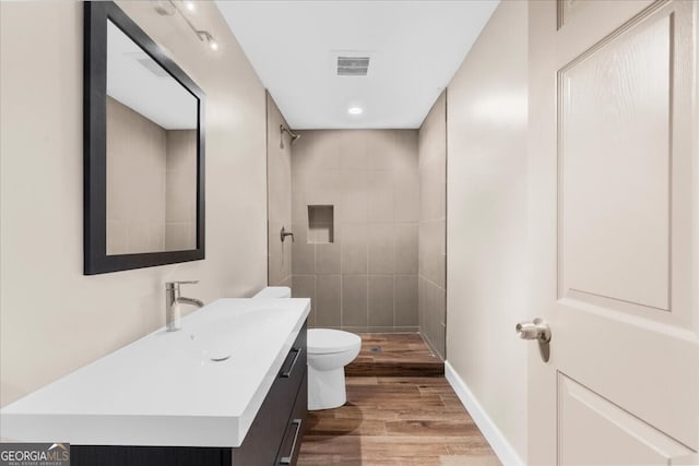 7049 Bennington Ln, Cumming, GA 30041 - bathroom featuring vanity, wood finished floors, tiled shower, and recessed lighting