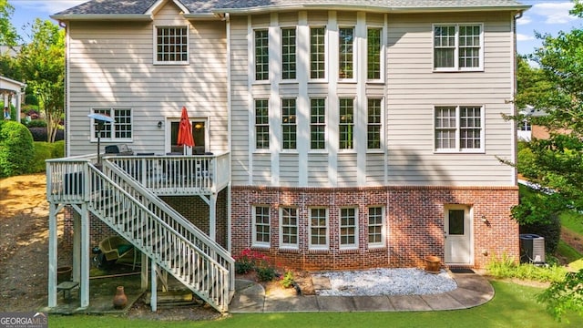 7049 Bennington Ln, Cumming, GA 30041 - rear view of house with brick siding, a wooden deck, and stairs