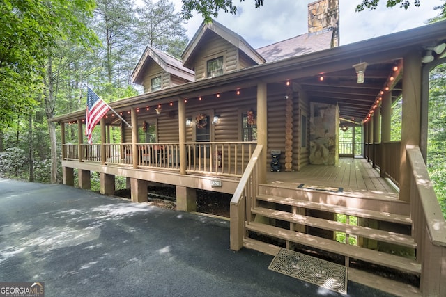 451 Pinecrest Rd, Sautee Nacoochee, GA 30571 - view of front facade featuring log exterior, a chimney, and covered porch
