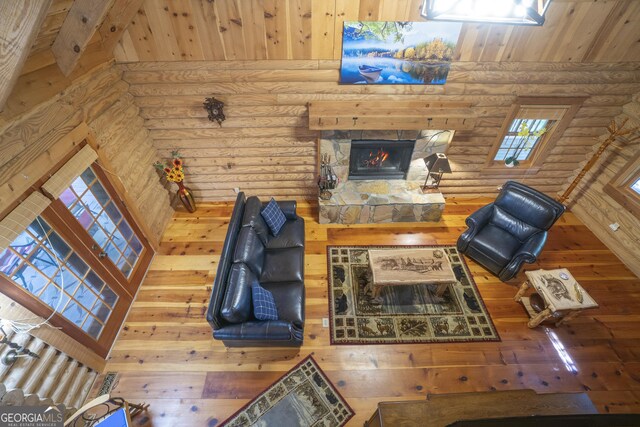 451 Pinecrest Rd, Sautee Nacoochee, GA 30571 - living room with rustic walls, hardwood / wood-style floors, a stone fireplace, and a towering ceiling