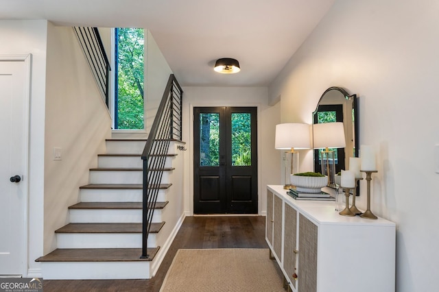 foyer entrance featuring dark wood-style floors, stairway, and baseboards