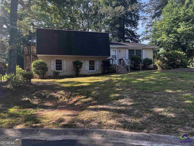 view of front of house with brick siding and a front yard