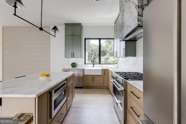 1954 8th St, Chamblee, GA 30341 - kitchen featuring appliances with stainless steel finishes, a sink, backsplash, light stone countertops, and light wood finished floors
