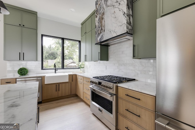 1954 8th St, Chamblee, GA 30341 - kitchen featuring appliances with stainless steel finishes, green cabinets, a sink, custom range hood, and light stone countertops