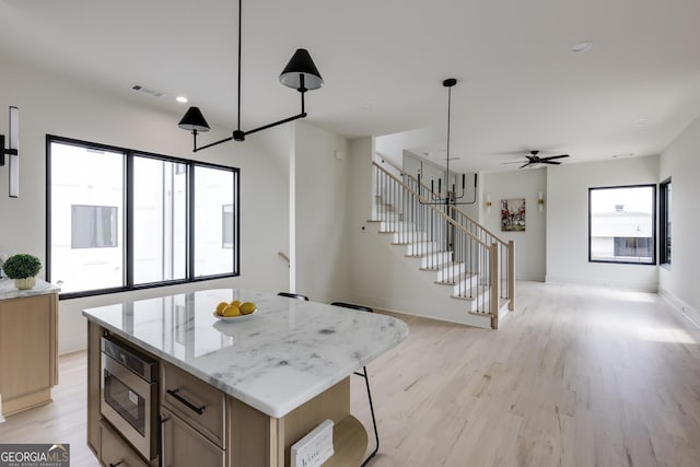 1954 8th St, Chamblee, GA 30341 - kitchen featuring stainless steel microwave, open floor plan, light wood-style floors, ceiling fan, and baseboards