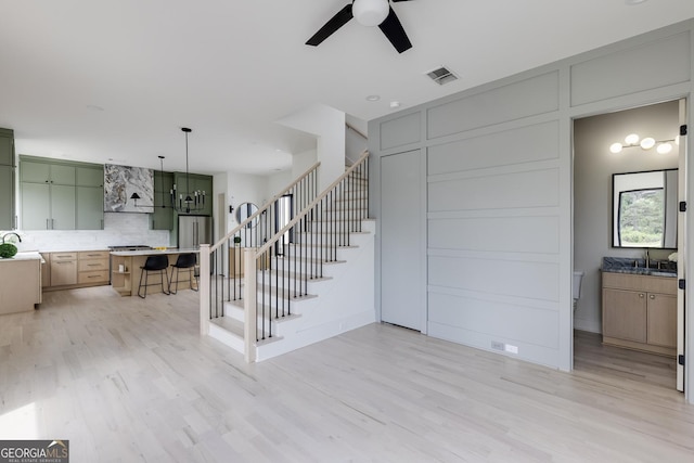 1954 8th St, Chamblee, GA 30341 - unfurnished living room featuring a ceiling fan, stairs, light wood finished floors, and a sink