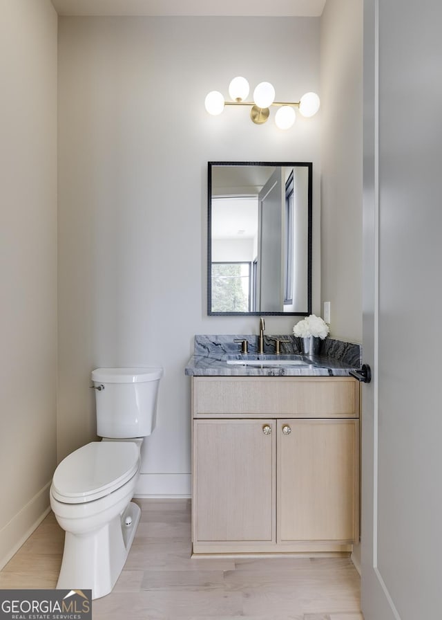 1954 8th St, Chamblee, GA 30341 - bathroom with baseboards, toilet, vanity, and wood finished floors