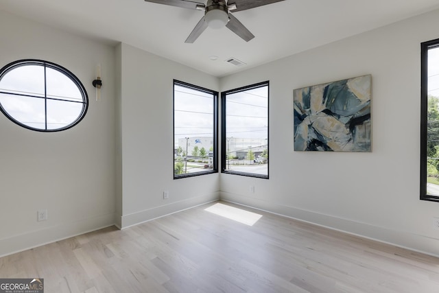 1954 8th St, Chamblee, GA 30341 - empty room with light wood finished floors, healthy amount of natural light, a ceiling fan, and baseboards
