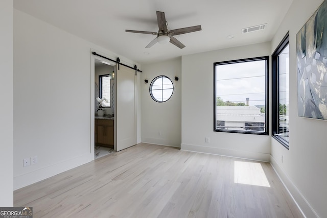 1954 8th St, Chamblee, GA 30341 - unfurnished room featuring a barn door, wood finished floors, ceiling fan, and baseboards